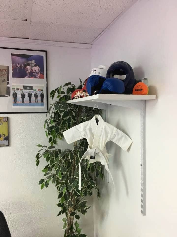 Karate uniform and sparring gear on a shelf